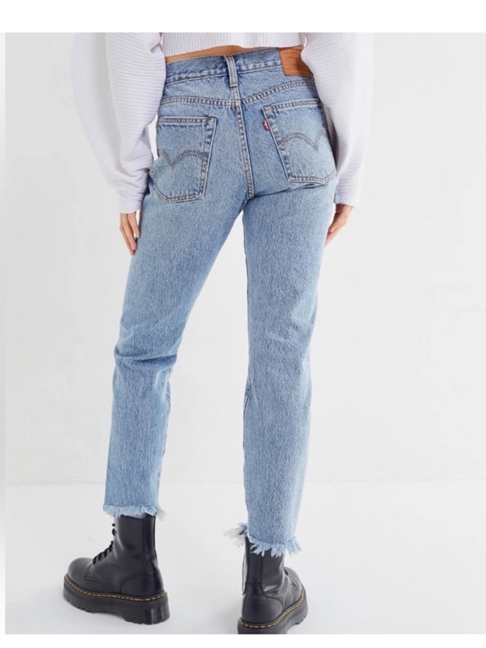 Levi Wedgie High Rise Ankle with distressed bottoms.